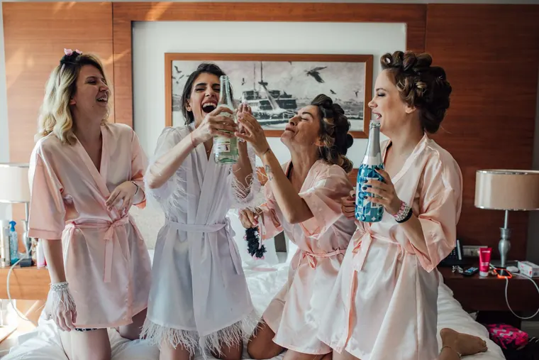 Bridesmaids in robes toasting in the morning