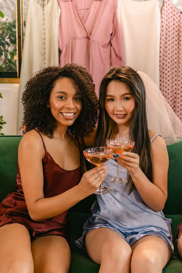 Two friends toasting with coupes